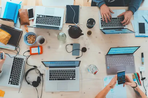 Team collaborating in a modern office with laptops and notes on a table